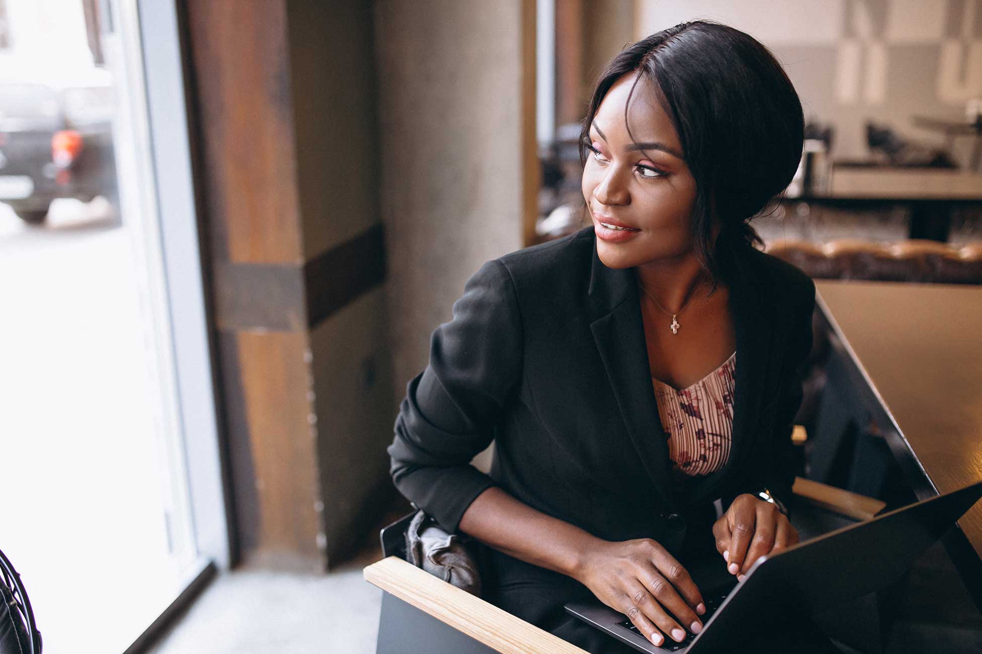 Professional African woman leader with laptop in executive workspace